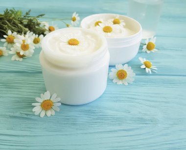 papatya çiçek, mavi ahşap arka plan üzerinde kozmetik krem