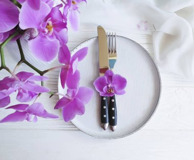 tabak çatal bıçak çiçek orkide Beyaz ahşap zemin üzerinde