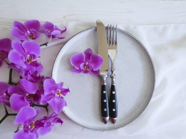 tabak çatal bıçak çiçek orkide Beyaz ahşap zemin üzerinde
