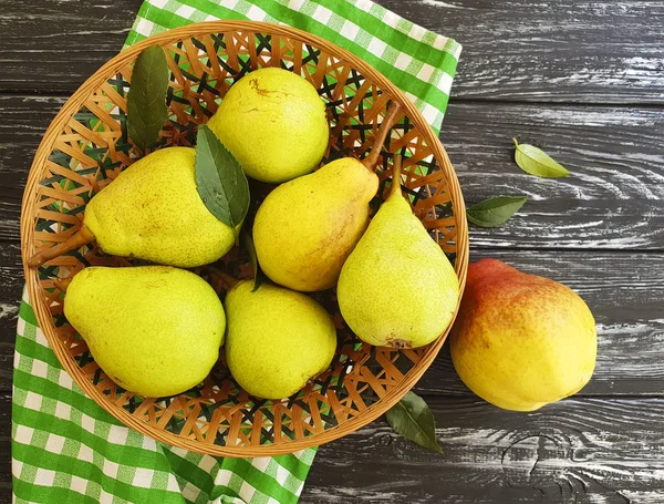 fresh organic pear on a black wooden background, plate