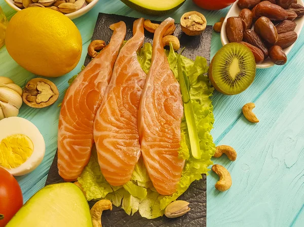 red fish, avocado, nuts on a blue wooden background, healthy food