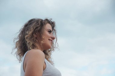 güzel kız mutlu portre kıvırcık saçlı gökyüzü arka plan üzerinde