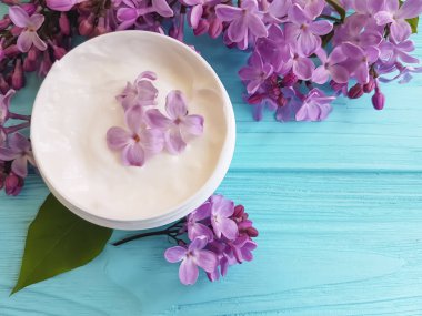 mavi ahşap arka plan üzerinde kozmetik krem Lila çiçek