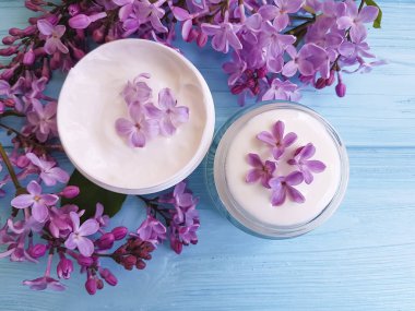 mavi ahşap arka plan üzerinde kozmetik krem Lila çiçek