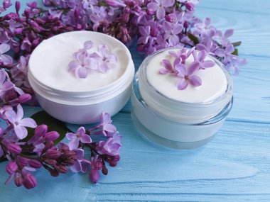 mavi ahşap arka plan üzerinde kozmetik krem Lila çiçek