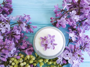 mavi ahşap arka plan üzerinde kozmetik krem Lila çiçek