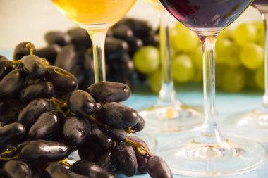 ahşap arka plan üzerinde şarap, yeşil ve mavi üzüm cam