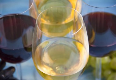 ahşap arka plan üzerinde şarap, yeşil ve mavi üzüm cam