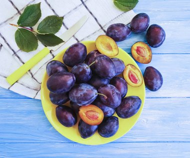 mavi ahşap arka plan üzerinde taze organik Erik