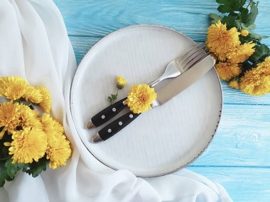 çatal, plaka, mavi ahşap zemin üzerine sarı kasımpatı bıçakla