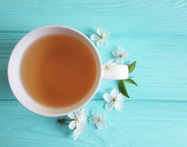 çay çiçek fincan kiraz, kayısı mavi ahşap zemin üzerine