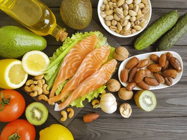 kırmızı balık, avokado, limon, kivi, koyu ahşap arka plan fındık