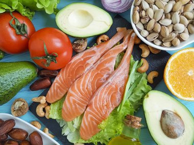 kırmızı balık, avokado, kivi, mavi ahşap arka plan üzerinde fındık