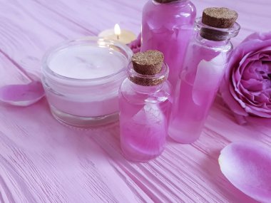 kozmetik krem, gül, özü, pembe ahşap arka plan üzerinde mum