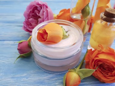 Krem Kozmetik taze gül turuncu mavi ahşap zemin, özü