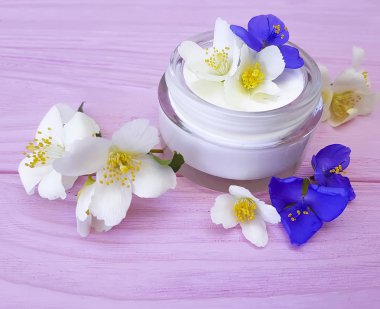 pembe ahşap arka plan üzerinde kozmetik krem Yasemin çiçeği