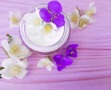 pembe ahşap arka plan üzerinde kozmetik krem Yasemin çiçeği