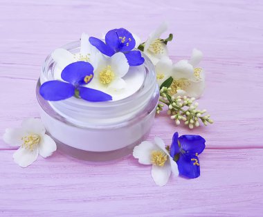 pembe ahşap arka plan üzerinde kozmetik krem Yasemin çiçeği