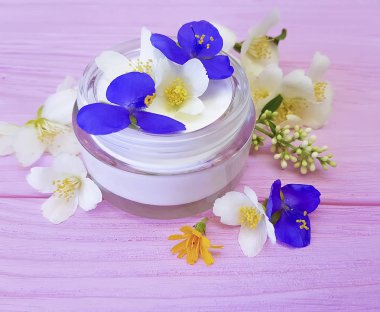 pembe ahşap arka plan üzerinde kozmetik krem Yasemin çiçeği