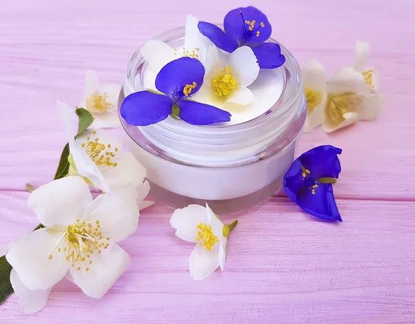 pembe ahşap arka plan üzerinde kozmetik krem Yasemin çiçeği