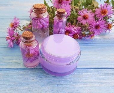 kozmetik krem, özü, mavi ahşap arka plan üzerinde kasımpatı çiçeği