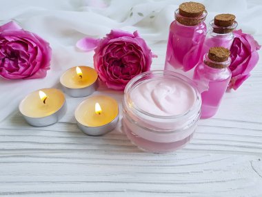 kozmetik krem, pembe gül özü ahşap arka plan üzerinde mum