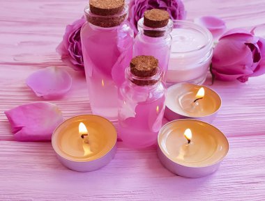 kozmetik krem, pembe gül özü ahşap arka plan üzerinde mum