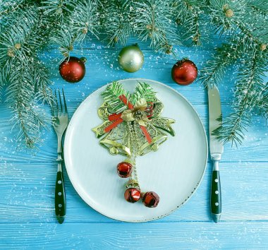 Noel ağacı dalı, bir plaka üzerinde mavi ahşap arka plan, kar