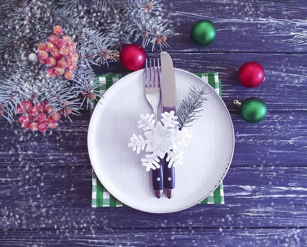 plate fork knife christmas tree branch wooden background snow