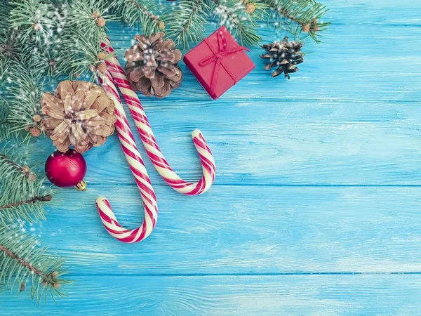 クリスマス ツリー ブランチ 青い木製の背景の上のキャンデー — ストック写真
