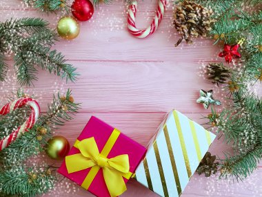 Noel ağacı dalı, pembe ahşap arka plan, kar üzerinde hediye kutusu