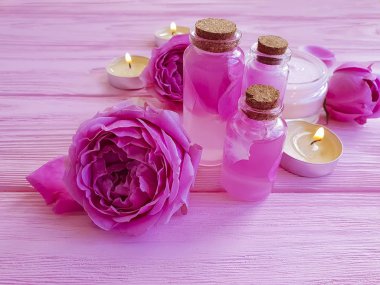 Krem Kozmetik, özü, gül çiçek, pembe ahşap zemin üzerine mum