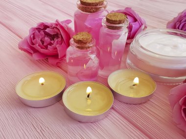Krem Kozmetik, özü, gül çiçek, pembe ahşap zemin üzerine mum