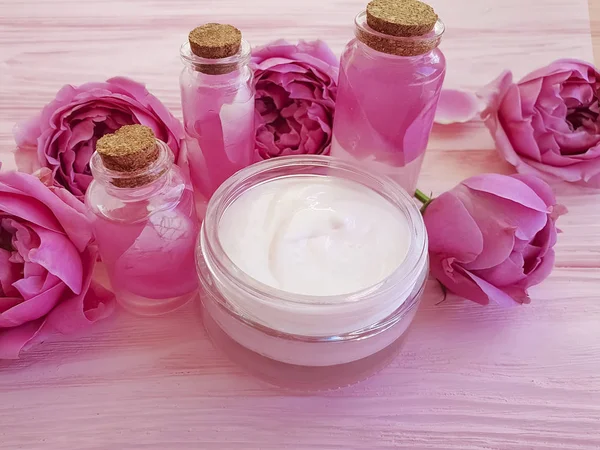 奶油化妆品 提取物 花玫瑰 在粉红色的木制背景 — 图库照片