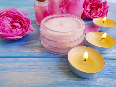 kozmetik krem, ayıklamak, mavi ahşap arka plan üzerinde gül çiçek,