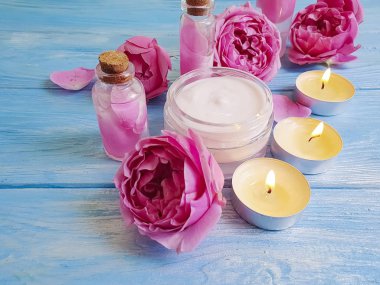 kozmetik krem, ayıklamak, mavi ahşap arka plan üzerinde gül çiçek,