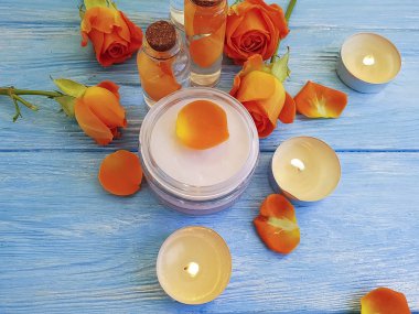 kozmetik krem, ayıklamak, mavi ahşap arka plan üzerinde gül çiçek,