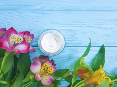 Alstroemeria çiçek, ahşap arka plan üzerinde kozmetik krem