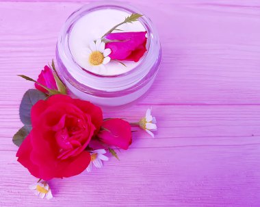gül çiçek, pembe ahşap arka plan üzerinde kozmetik krem