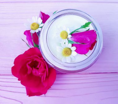 gül çiçek, pembe ahşap arka plan üzerinde kozmetik krem