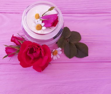 gül çiçek, pembe ahşap arka plan üzerinde kozmetik krem