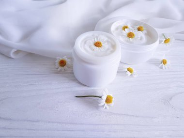 papatya çiçek, Beyaz ahşap zemin üzerinde kozmetik krem
