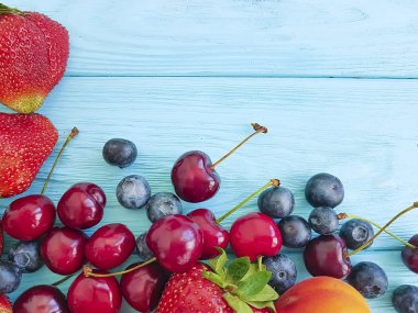ahşap arka plan üzerinde çilek, kiraz, yaban mersini