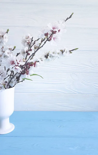 ahşap arka plan üzerinde bir vazoda kiraz çiçekleri