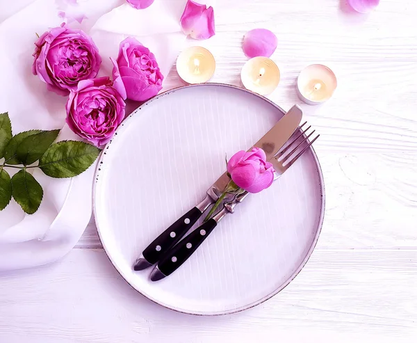 plate, flower rose, candle on wooden background