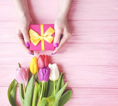 hediye kutusu, Lale pembe ahşap arka plan üzerinde buket kadın el ele tutuşur