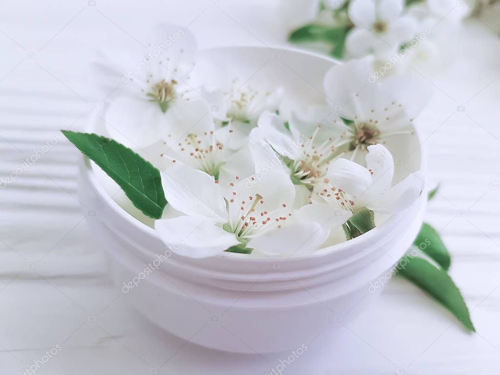 cosmetic cream blooming cherry on a white wooden background