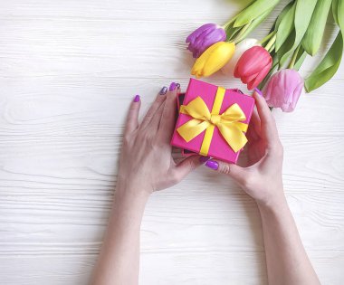 hediye kutusu, Lale çiçek ahşap arka plan üzerinde tutan eller