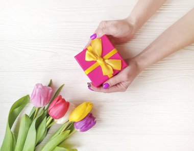 hediye kutusu, Lale çiçek ahşap arka plan üzerinde tutan eller