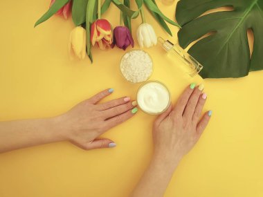 eller manikür, krem, Lale çiçek sarı bir arka plan üzerinde